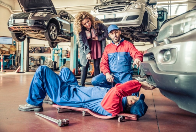Mechanics working on damaged car